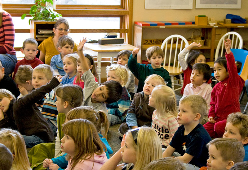 Students at Montessori school listening to musicians